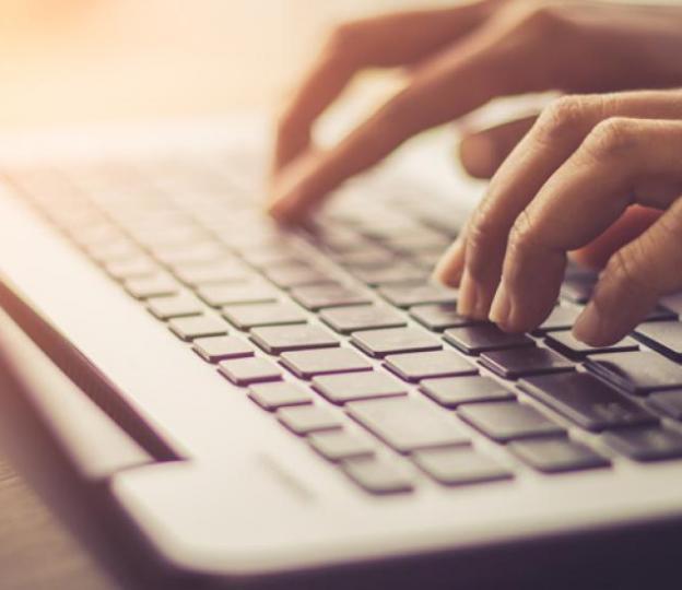 Closeup of hands typing on laptop