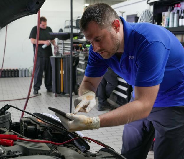 Technician looking at car