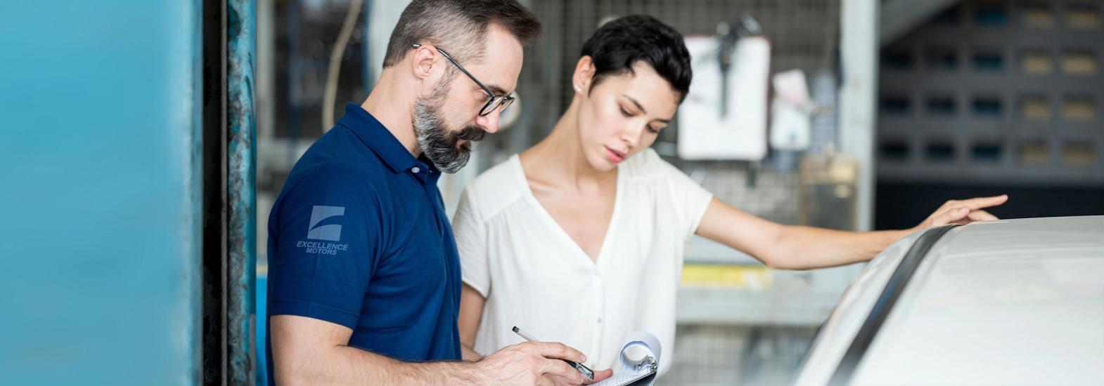 man and woman looking at car