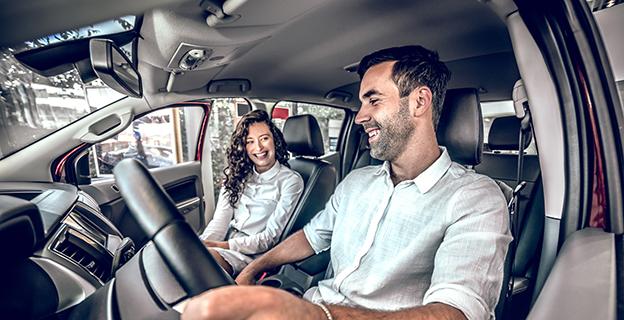 A couple inside a new car in the showroom.