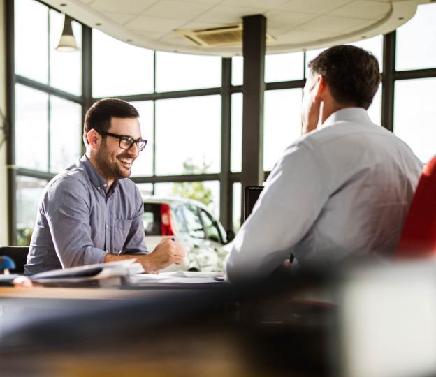 Two people sitting in car dealership